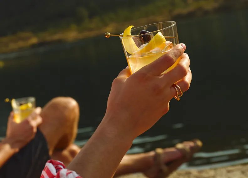 Hand Holding Glass Lake Sunset Maker’s Mark