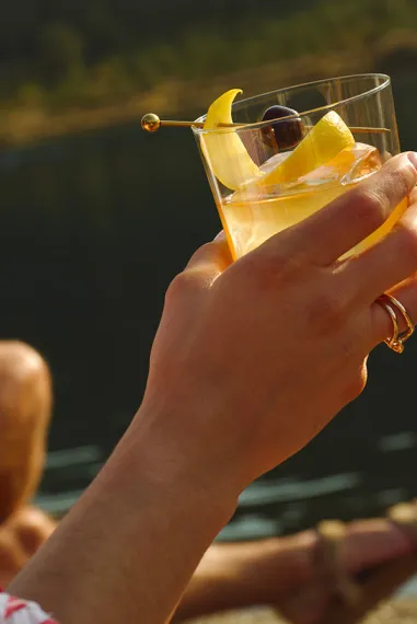 Hand Holding Glass Lake Sunset Maker’s Mark