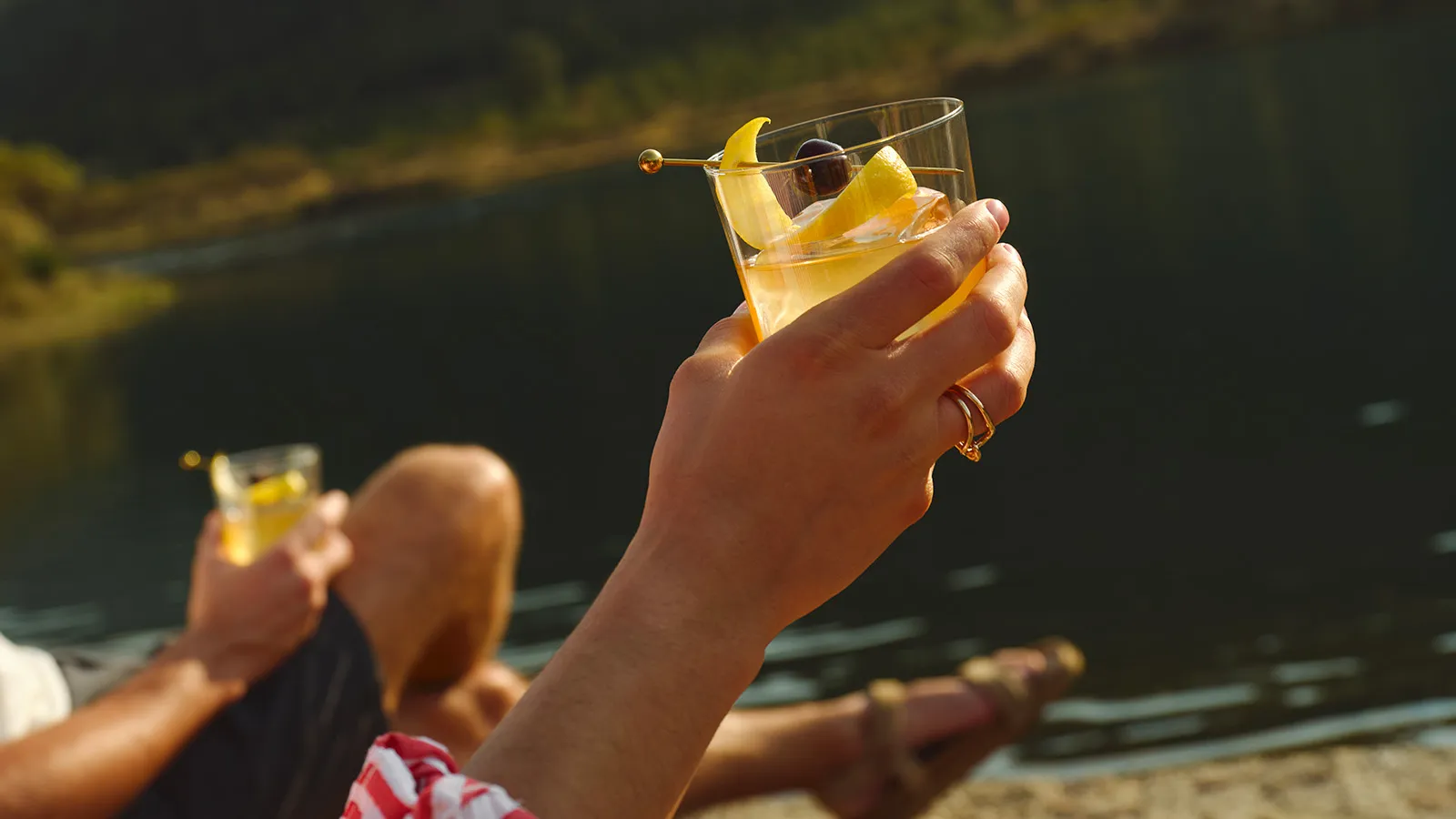 Hand Holding Glass Lake Sunset Maker’s Mark