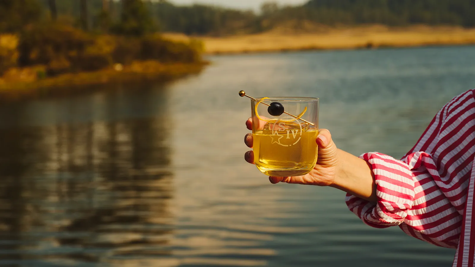 Hand Holding Glass Striped Shirt Sunset Maker’s Mark
