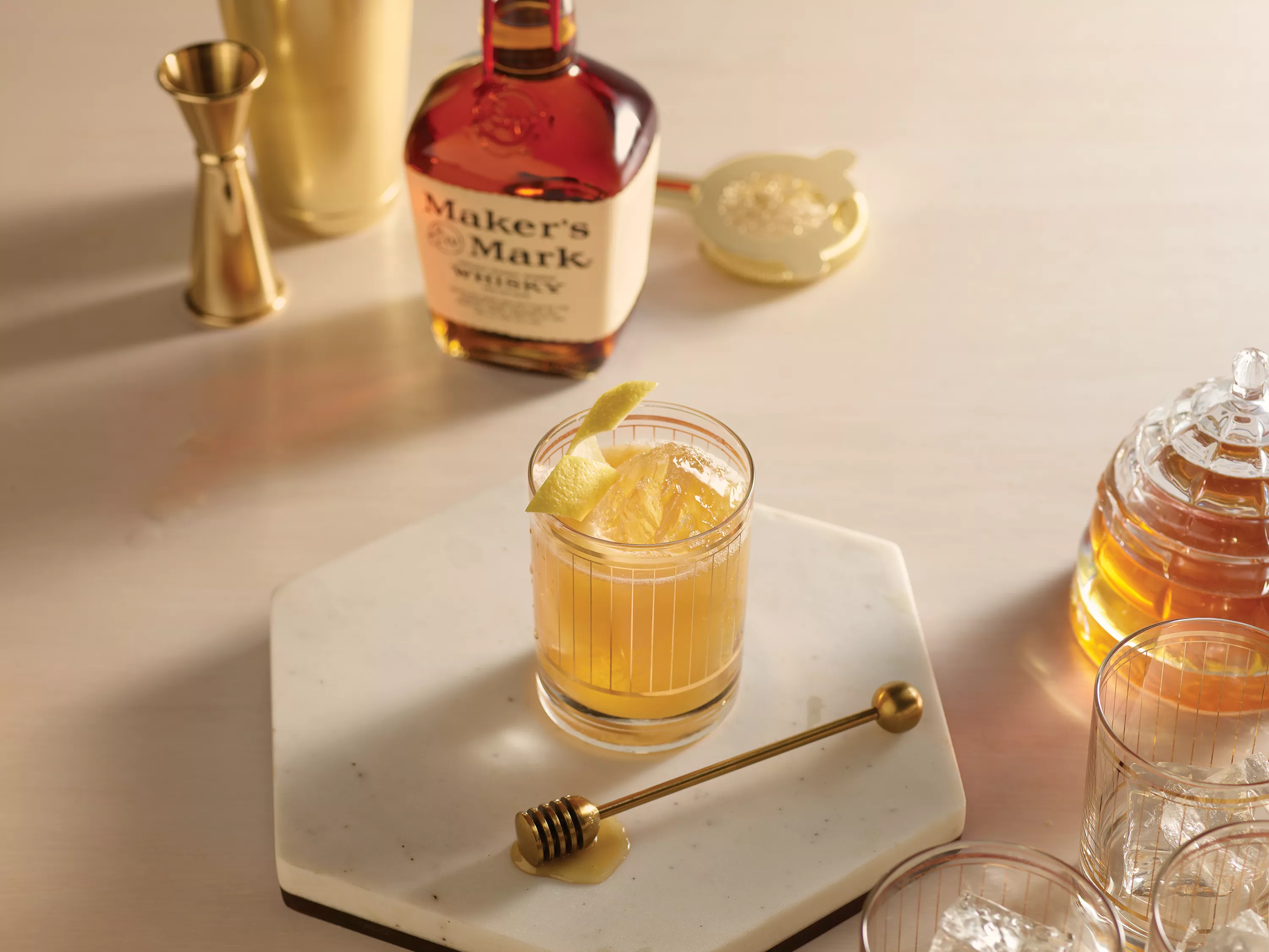 Flat lay of Maker's Mark bourbon whisky with cocktail and cocktail garnishings