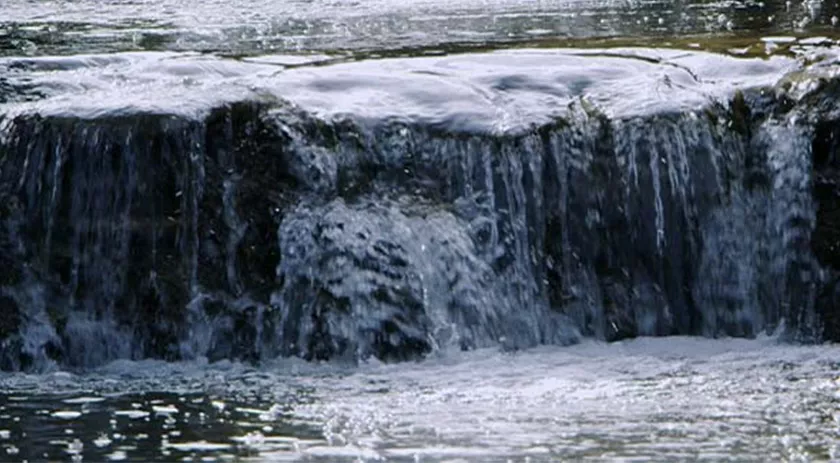 A waterfall of Kentucky's limestone mineral water is shown running into the river on the Maker's Mark distillery property. 