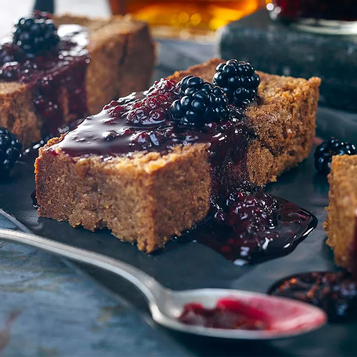 close up shot of blondies with spoon covered in blueberry topping sauce