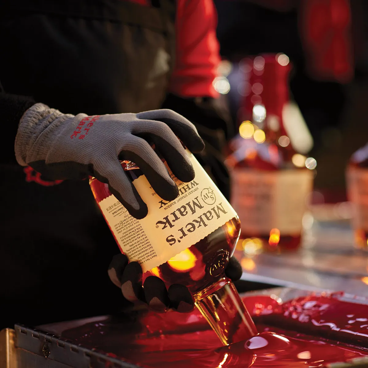 Applying wax seal to Maker’s Mark bourbon bottle